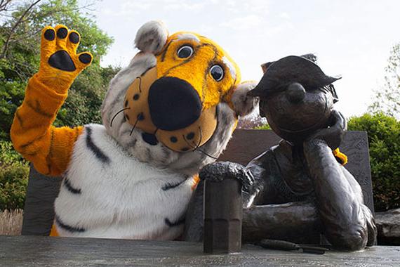 Truman Tiger mascot waving with an arm around the Beetle Bailey statue